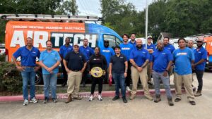 air tech team standing with belt in front of van